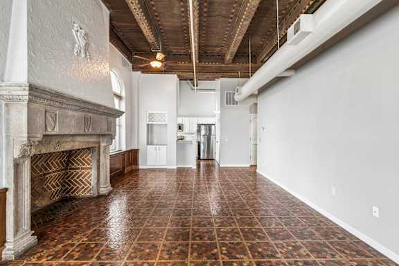 A large room with a fireplace and tiled flooring.