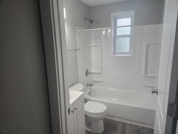 A white bathroom with a toilet, sink, and bathtub.