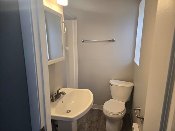 A white toilet sits next to a sink in a small bathroom.