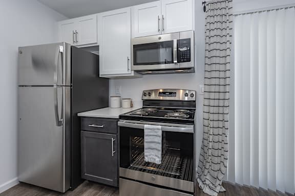 A kitchen with a stainless steel refrigerator, microwave, and oven. at Ten31, Dayton, OH, 45458