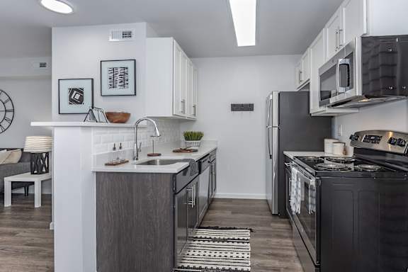 A modern kitchen with black and white appliances and a wooden island. at Ten31, Dayton, 45458