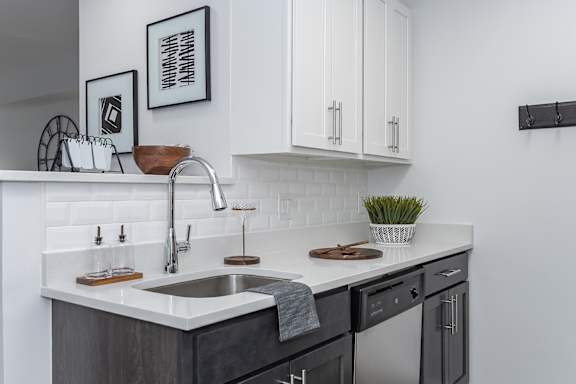 A modern kitchen with a white countertop and black cabinets. at Ten31, Dayton, Ohio