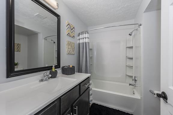 A bathroom with a white sink and a white bathtub at Indian Lookout Apartments, West Carrollton, OH
