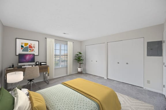a bedroom with a bed and a desk and a tv