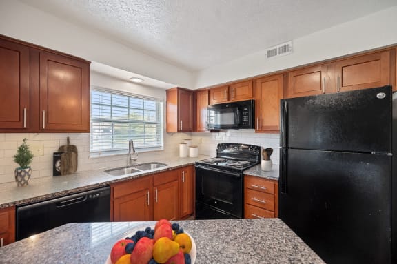 a kitchen with black appliances and granite counter tops