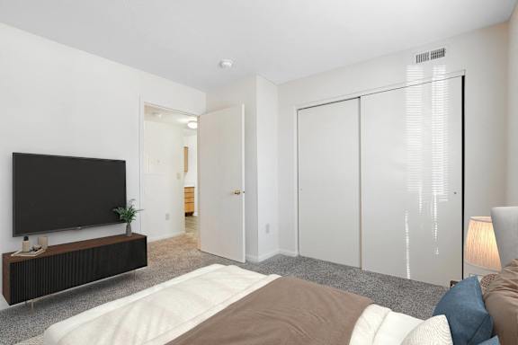 A bedroom with a bed, a television, and a lamp.