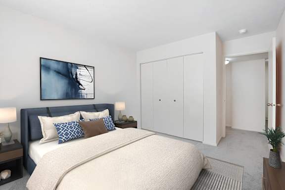 A bedroom with a large bed and a painting on the wall.