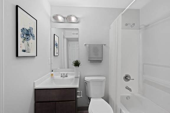 A white bathroom with a toilet, sink, and bathtub.