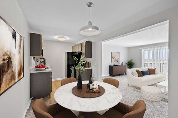 A modern living room with a round marble table and brown chairs.
