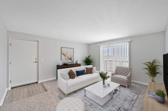 A living room with a white couch, a coffee table, and a painting on the wall.