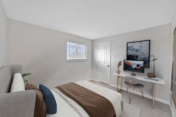 A bedroom with a bed, a couch, and a painting on the wall.