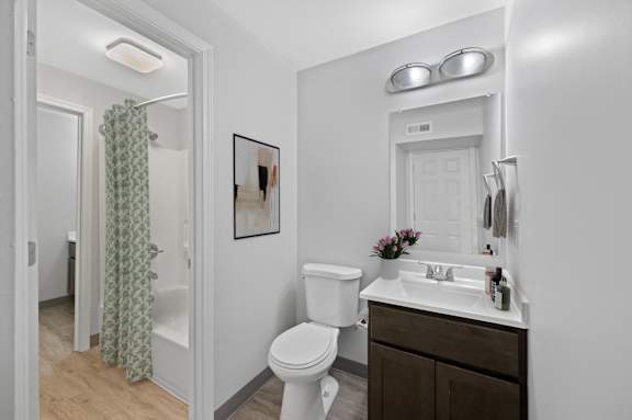 A white toilet sits in a bathroom next to a sink.