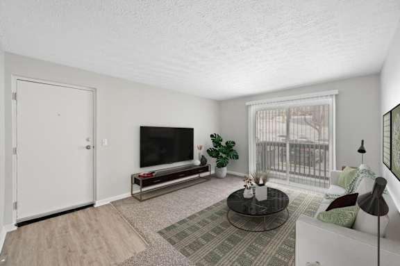 A living room with a flat screen TV and a balcony.