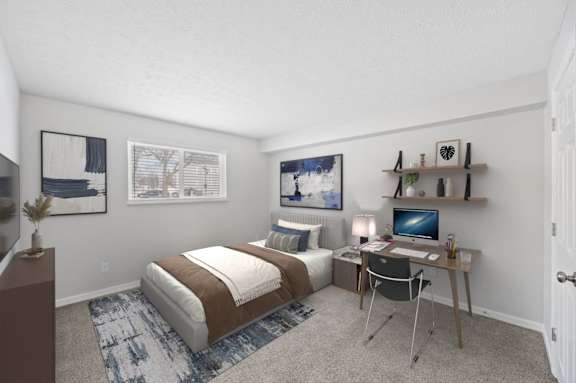 A bedroom with a bed, desk, and chair.