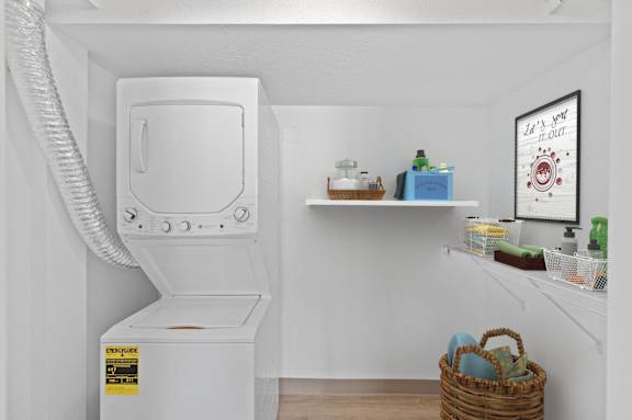A white washing machine with a basket underneath it.