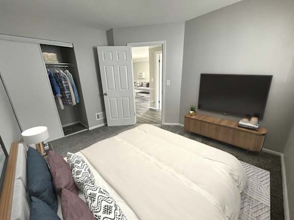 A bedroom with a large bed, a television, and a wardrobe.