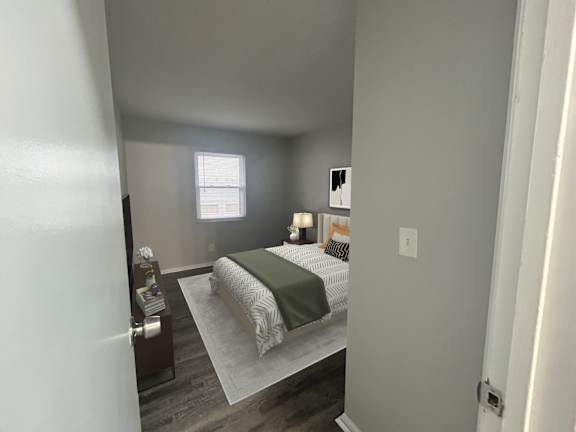 A bedroom with a bed, nightstand, and window.