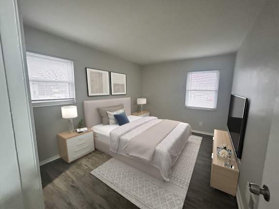 A bedroom with a bed, nightstands, and a window.