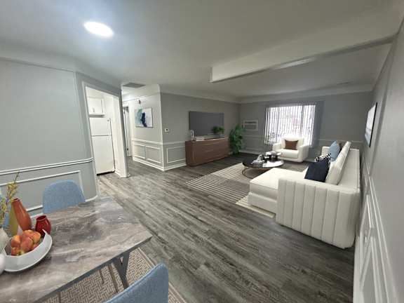 A living room with a grey table and a bowl of fruit on it.
