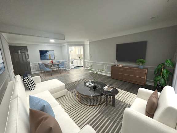 A living room with a white couch, a coffee table, and a television.