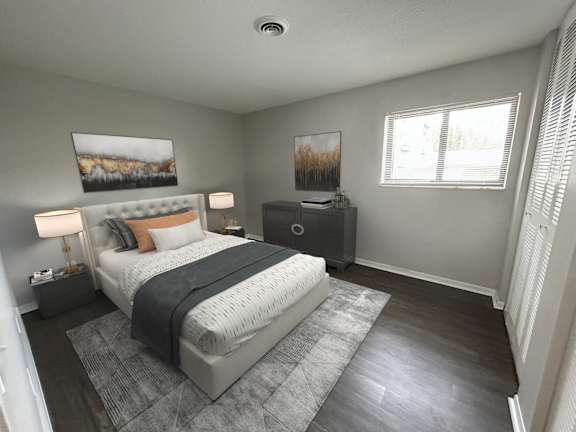 A bedroom with a large bed, a nightstand, and a painting on the wall.