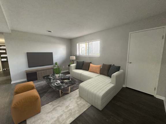 A living room with a white couch, orange chairs, and a flat screen TV.
