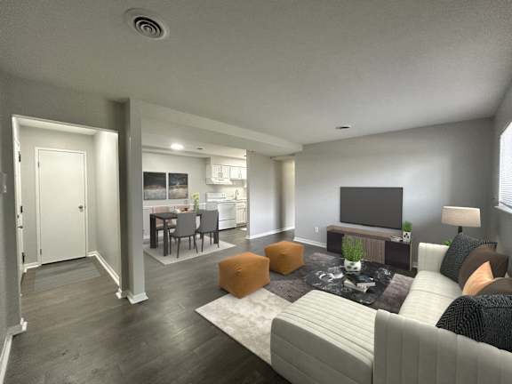 A modern living room with a grey couch, a fireplace, and a television.
