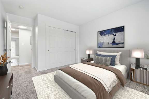 A bedroom with a large bed and a painting on the wall.