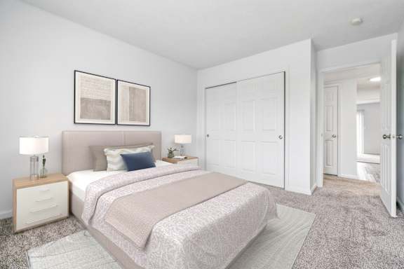 A bedroom with a large bed and two nightstands with lamps.