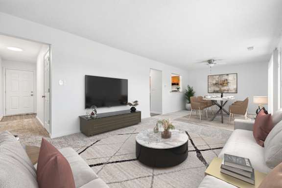 A modern living room with a flat screen TV, a coffee table, and a couch.