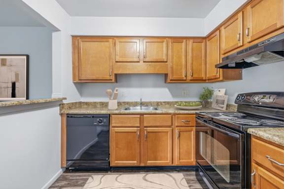 A kitchen with wooden cabinets and a granite countertop.