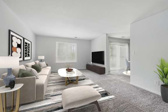 A living room with a grey sofa, a white coffee table, and a television.