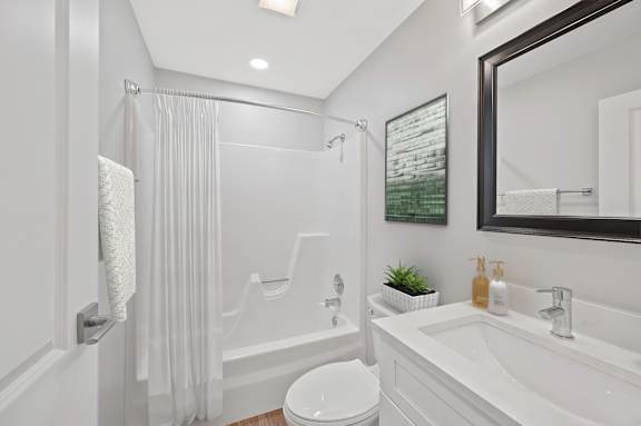 A white bathroom with a toilet, sink, and shower. at Indian Creek Apartments*, Ohio, 45236