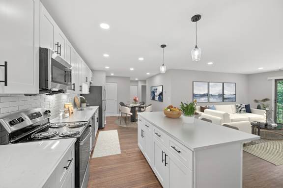 A modern kitchen with white cabinets and a large island. at Indian Creek Apartments*, Cincinnati, Ohio