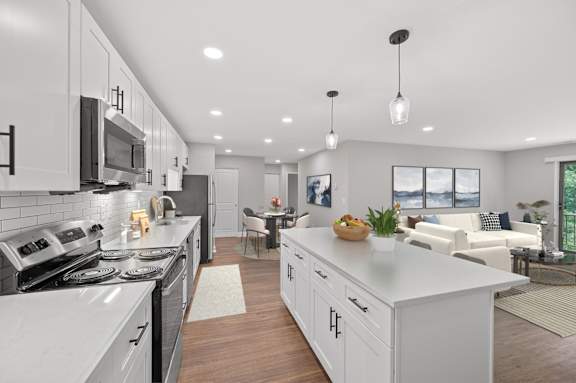 A modern kitchen with white cabinets and a large island. at Indian Creek Apartments*, Cincinnati, OH, 45236