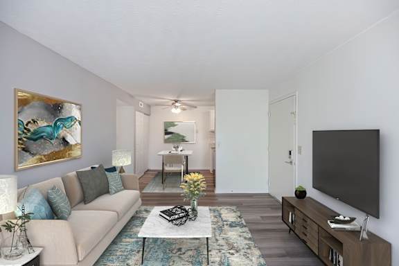 A living room with a couch, a coffee table, and a painting on the wall.