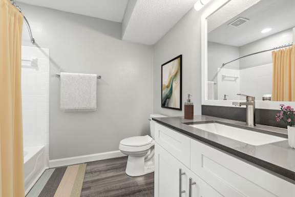A bathroom with a toilet, sink, and mirror.at Hanna Village, Indiana, 46227