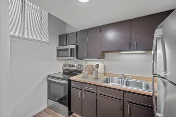 A kitchen with brown cabinets and stainless steel appliances.