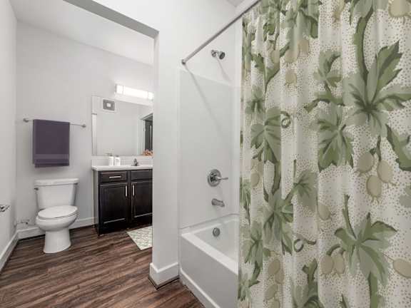A bathroom with a toilet, sink, and shower curtain. at River View at Bexley Apartments, River View at Bexley, Ohio
