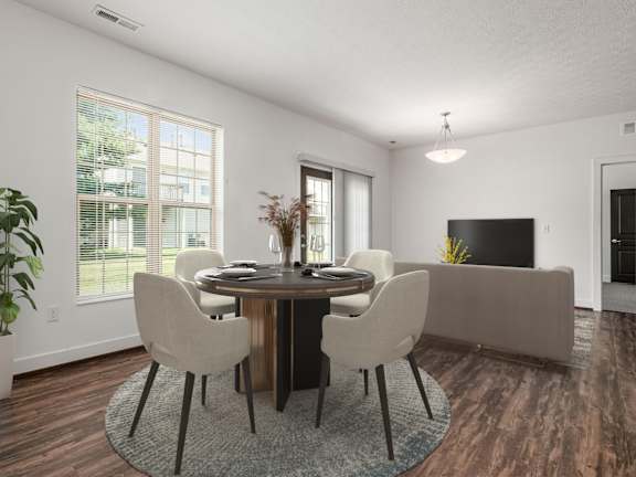 A dining room with a table set for four and a television. at River View at Bexley Apartments, River View at Bexley 43209