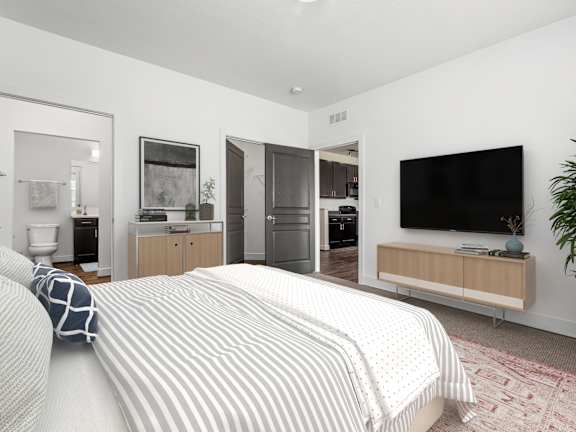 A bedroom with a bed, a television, and a potted plant. at River View at Bexley Apartments, River View at Bexley 43209