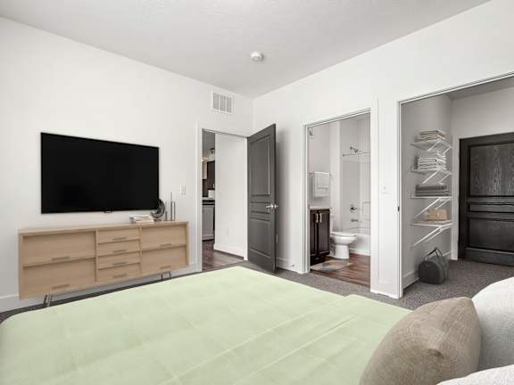 A bedroom with a bed, dresser, and a television. at River View at Bexley Apartments, River View at Bexley, Ohio