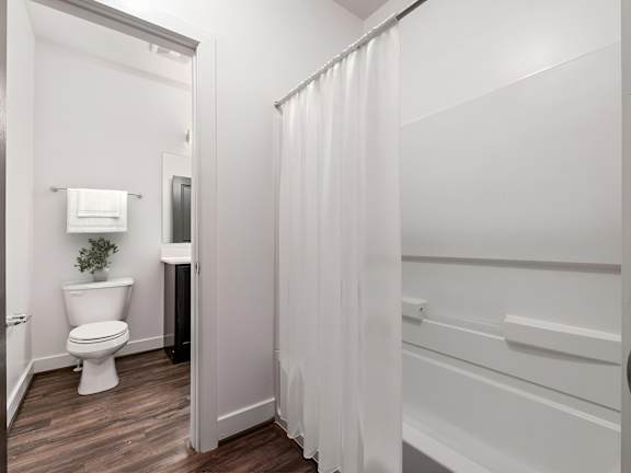 A white bathroom with a toilet and a shower. at River View at Bexley Apartments, River View at Bexley 43209