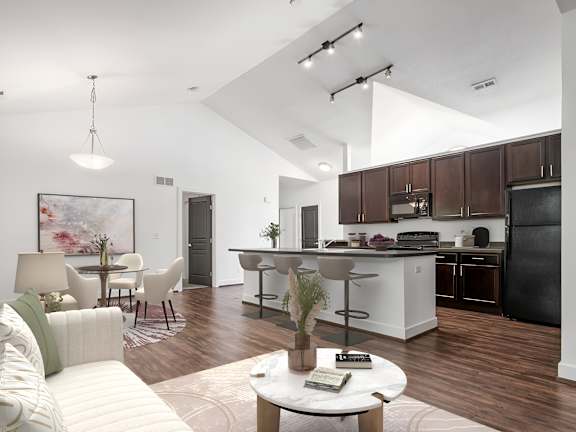 A modern kitchen with dark brown cabinets and a black refrigerator. at River View at Bexley Apartments, Ohio, 43209