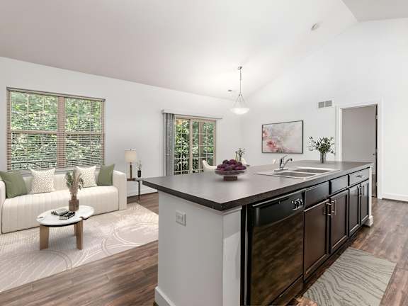 A modern kitchen with dark wood cabinets and a white island. at River View at Bexley Apartments, Ohio