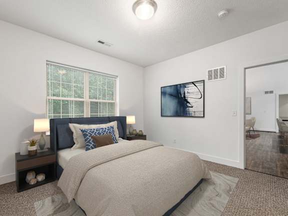 A bedroom with a large bed and a painting on the wall. at River View at Bexley Apartments, River View at Bexley, Ohio