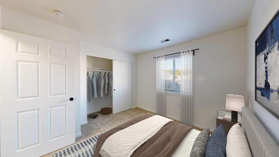 A bedroom with a large bed and a painting on the wall.