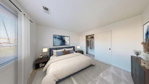A bedroom with a large bed and a painting on the wall.
