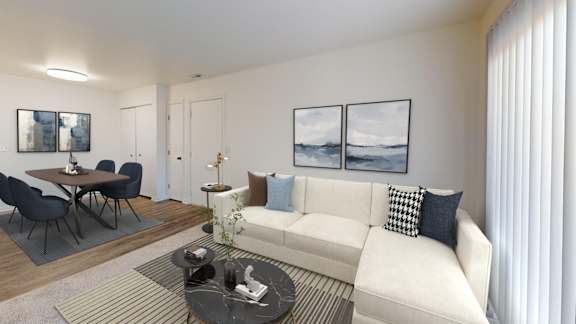A living room with a white couch, a coffee table, and a dining table with chairs.