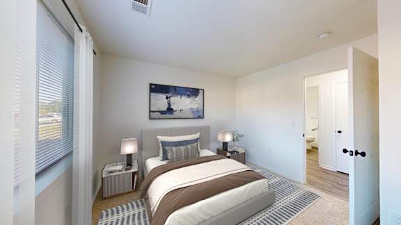A bedroom with a bed, two lamps, and a painting on the wall.